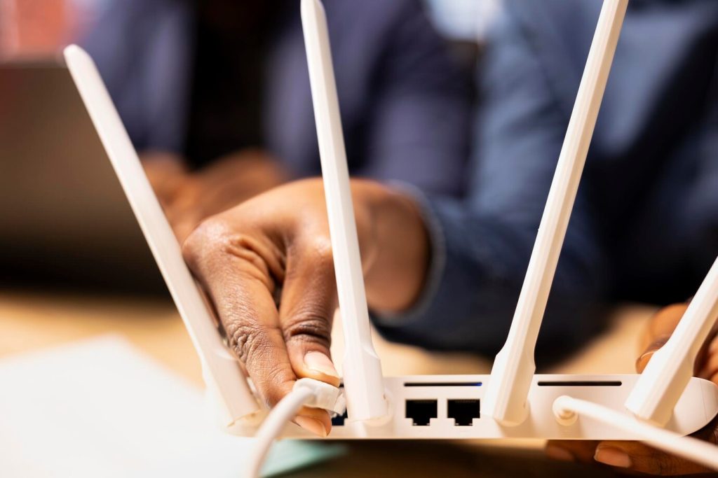 young-black-woman-pulling-out-lan-cable-from-modem_482257-118912-1024x683
